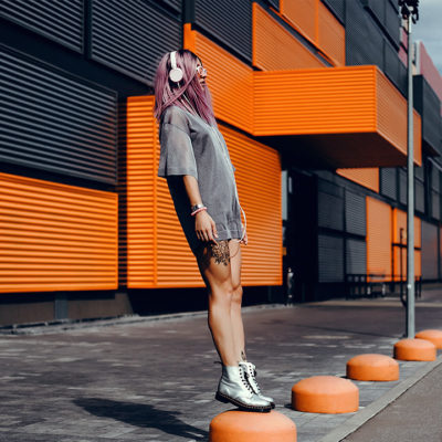 Girl with pink hair listening to headphones.