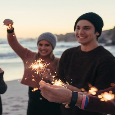 People holding sparklers on the beach