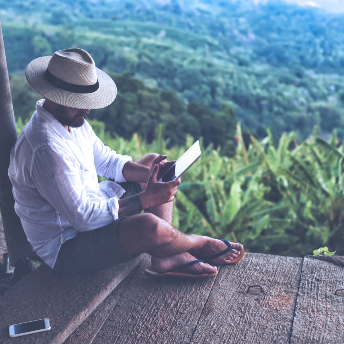 Man sitting above the clouds with an iPad.