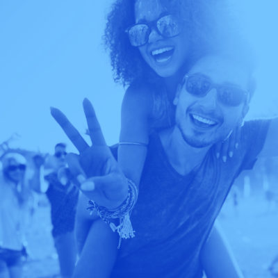 Couple at a party hold up a peace sign.