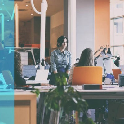 A group of women have a conversation about SEO in a modern office space.