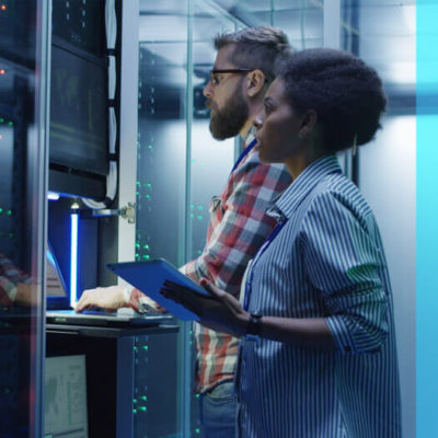 A man and a woman work on a computer server together.