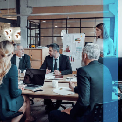 A group of marketers work together at a communal table in an office.