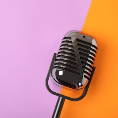 Retro microphone on color background, top view with space for text