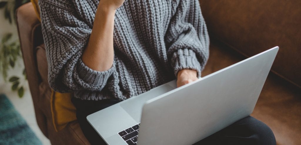 lady in sweater on a laptop