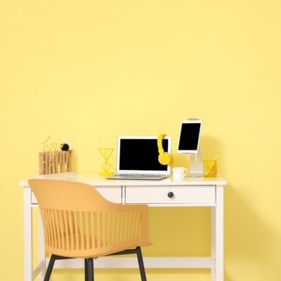 Stylish workplace with modern gadgets against color wall in room