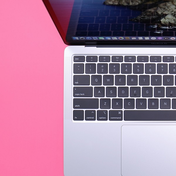 Mac laptop in front of pink background