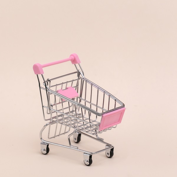 Mini shopping trolley on beige background