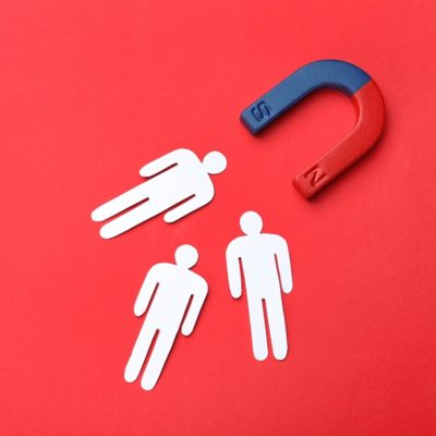 Magnet attracting people traffic on color background, top view with space for text. Marketing concept