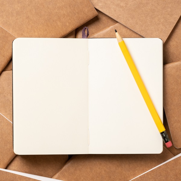 open notebook with pencil on brown kraft notebook disorder alignment on table background