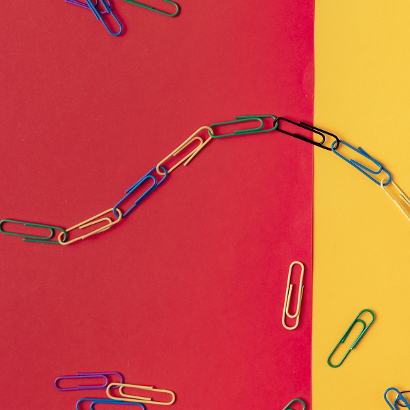 colorful paper clips chain in form of snake on the table surface