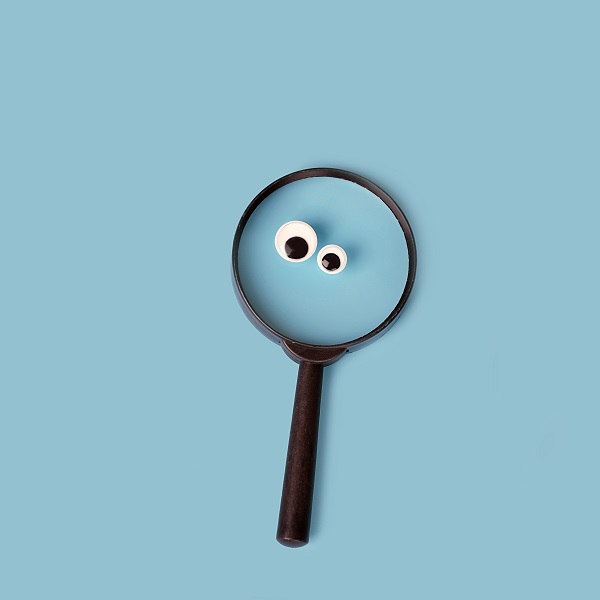 magnifying glass with google eyes on blue background. magnifier loupe - search symbol. minimal creative concept. copy space.