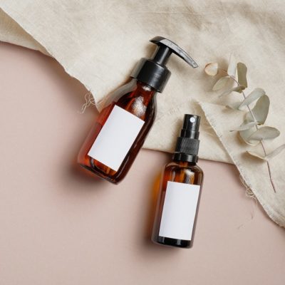 Amber glass cosmetic bottles set with towel and eucalyptus leave