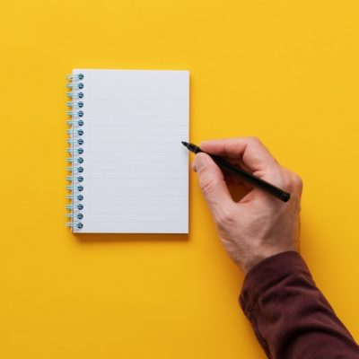 Male hand writing in notepad