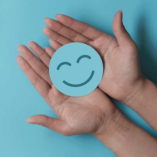 Hand holding blue paper cut happy smile face, positive thinking, Talk with clients about SEO services