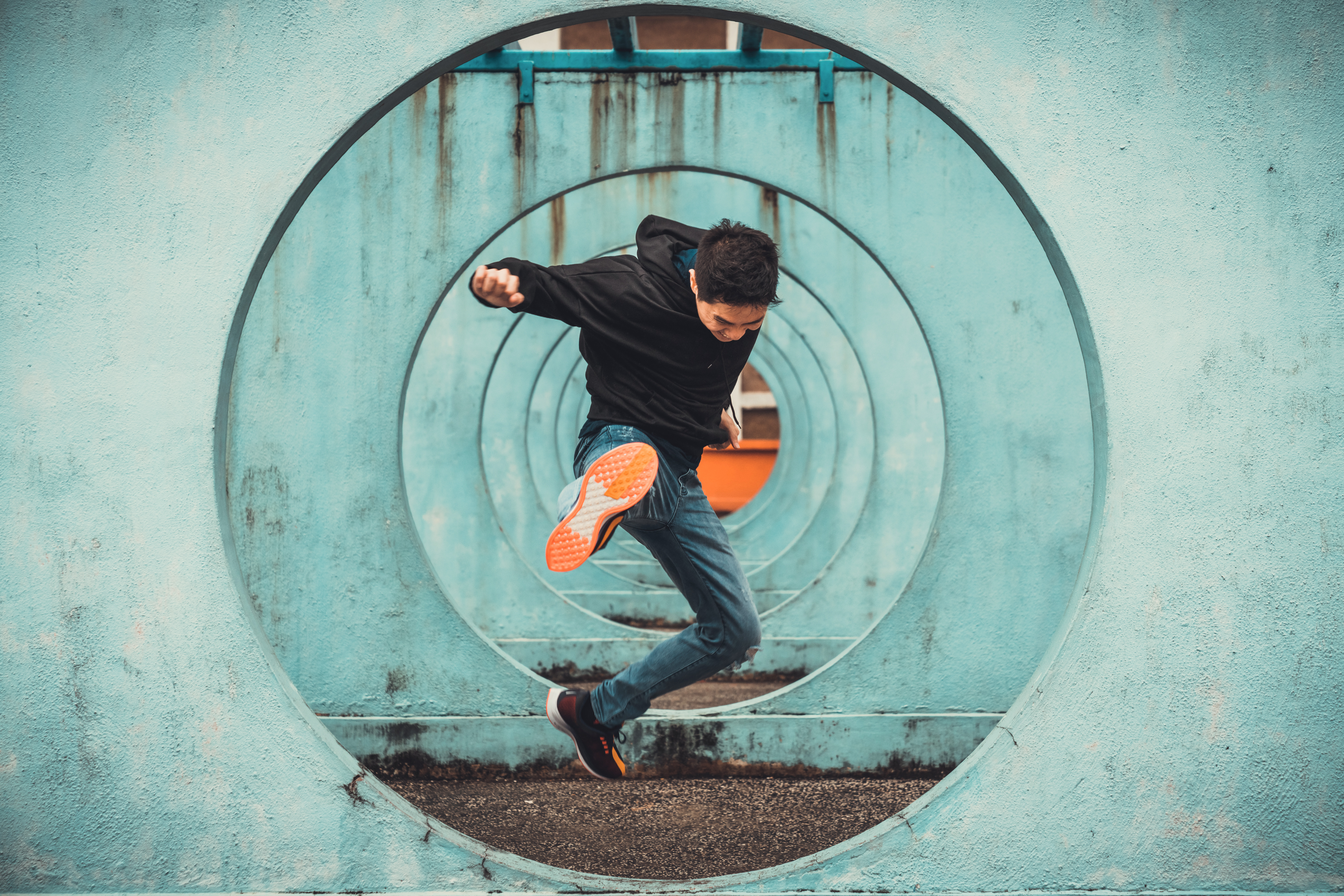 Guy jumping through colored tunnel.