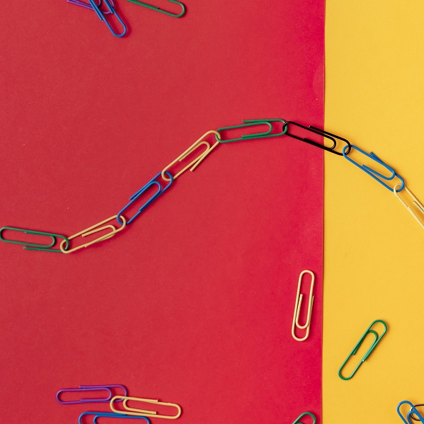 colorful paper clips chain in form of snake on the table surface colorful paper clips chain in form of snake on the table surface