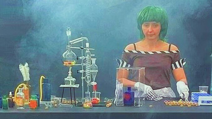A disappointed woman with green hair standing behind a sparse table with laboratory glassware and single candies, illustrating a marketing failure.