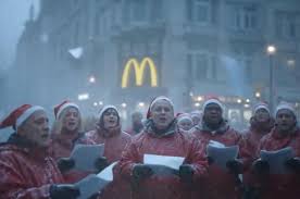 An AI-generated image of a crowd of carolers in red jackets in front of a McDonald's restaurant, with distorted facial features and blurred details.